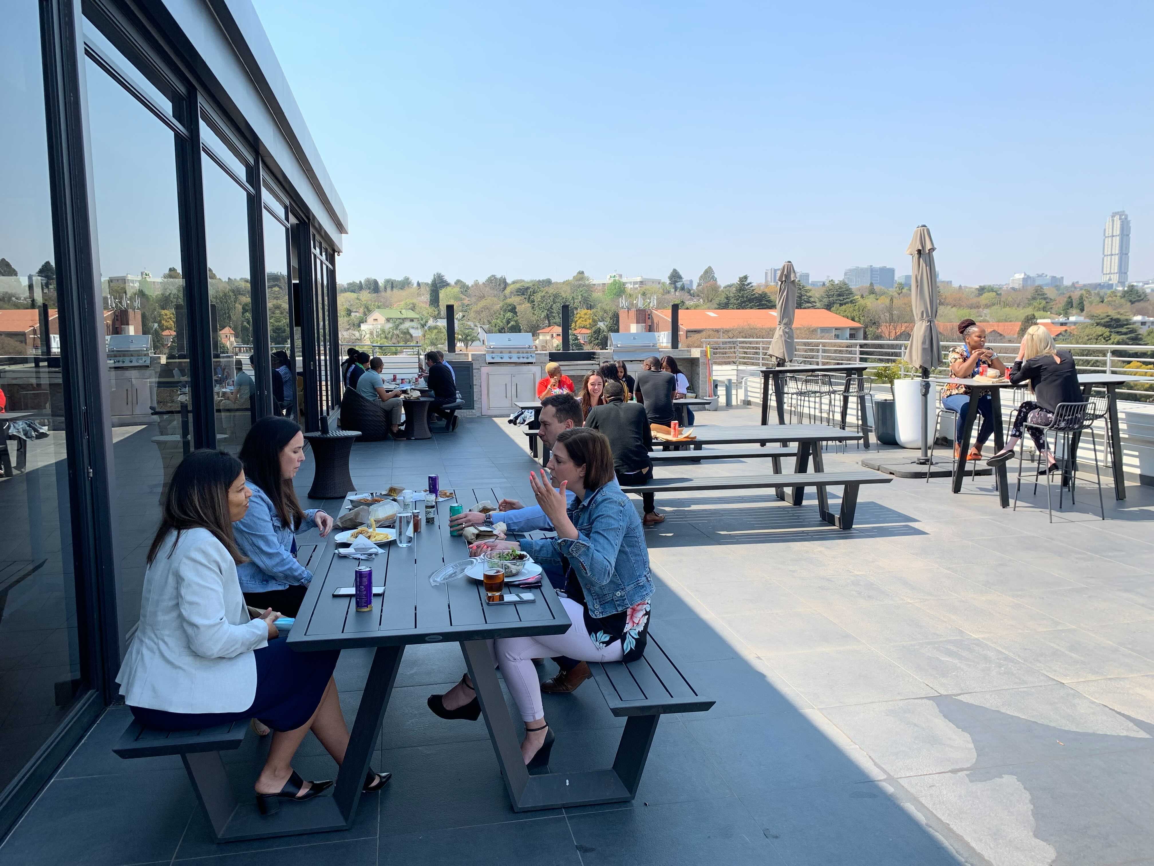 a group of people sitting at a table on a rooftop