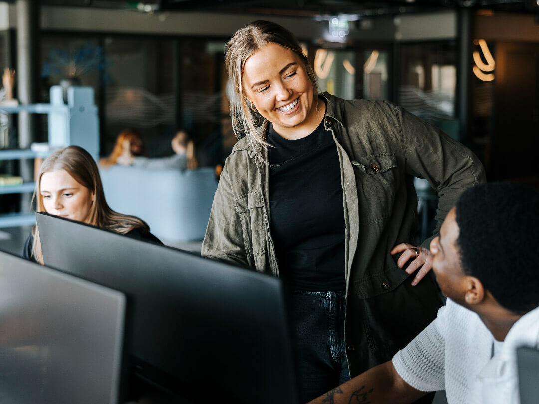 a woman smiling at a man in front of a computer