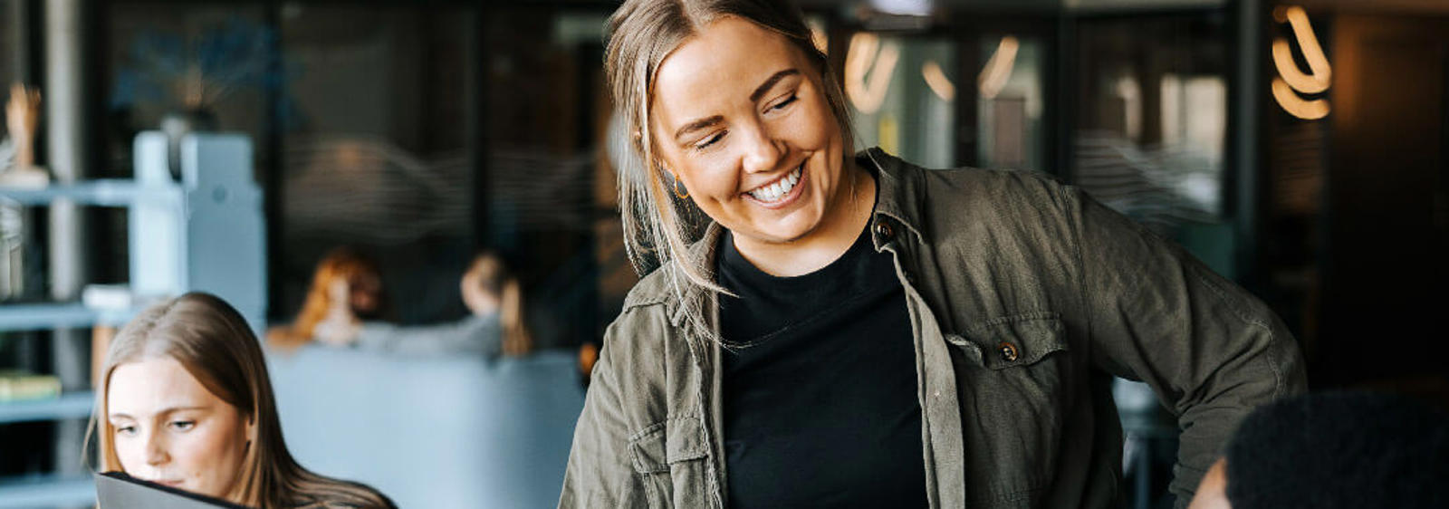 a woman smiling at a man in front of a computer