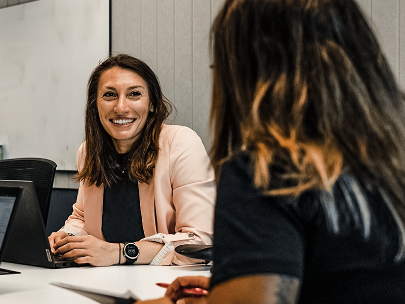 a woman smiling at another woman