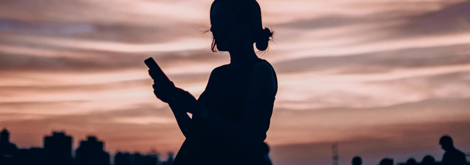 a silhouette of a woman holding a phone