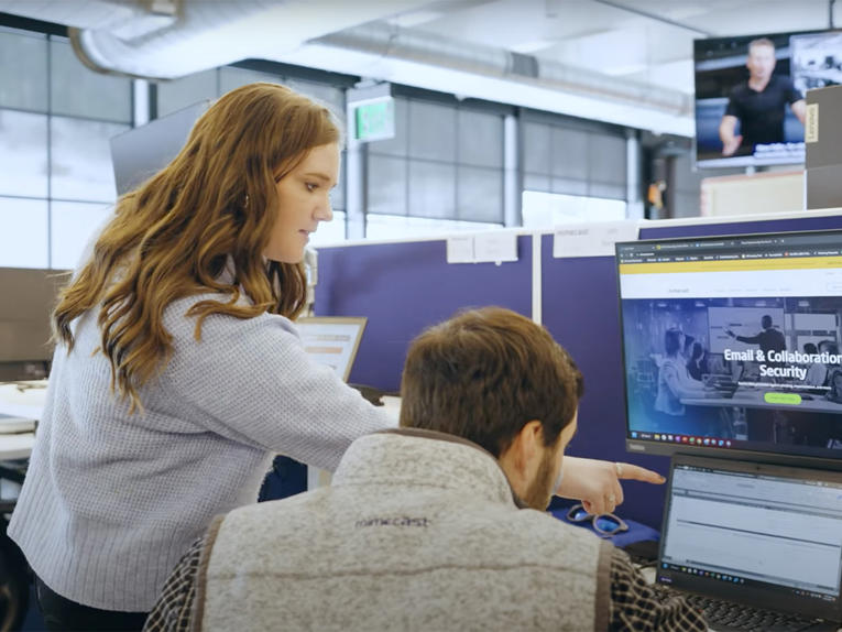 a woman pointing at a computer screen