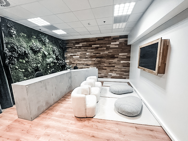 a room with a reception desk and white chairs