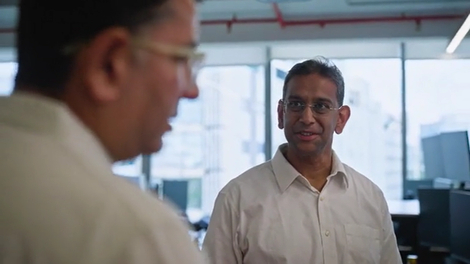 a man in a white shirt talking to another man