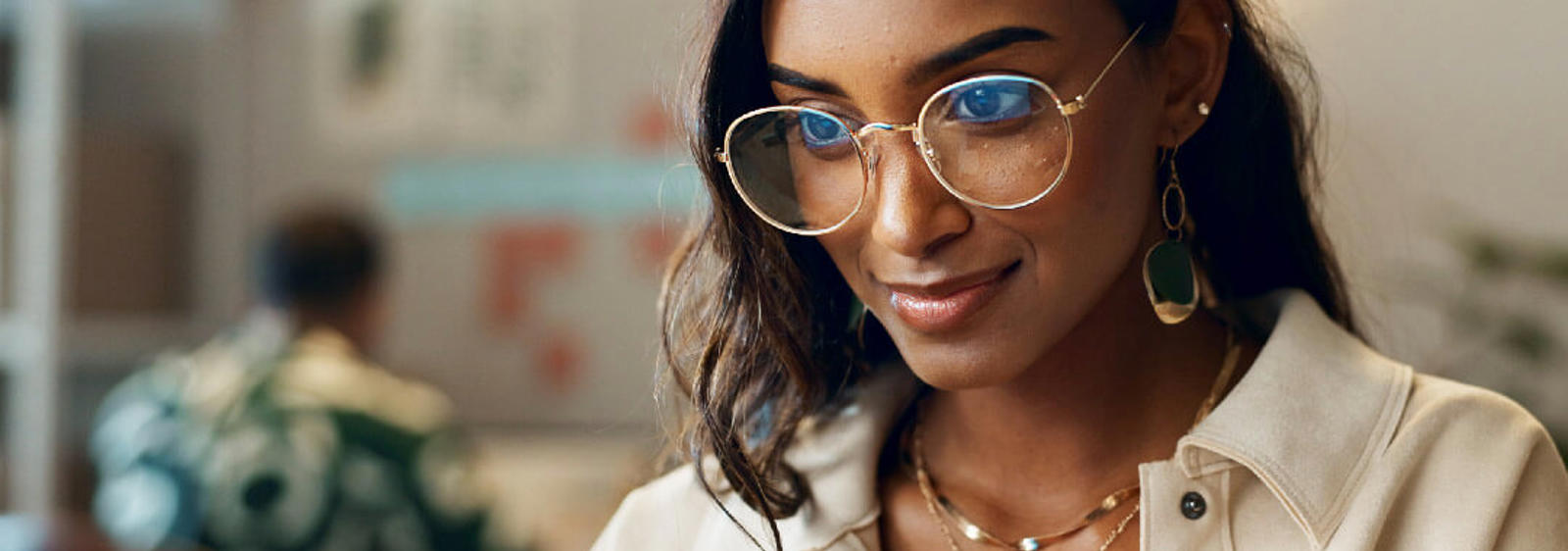 a woman wearing glasses and a white jacket