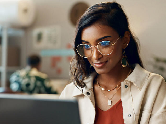 a woman wearing glasses and a white jacket