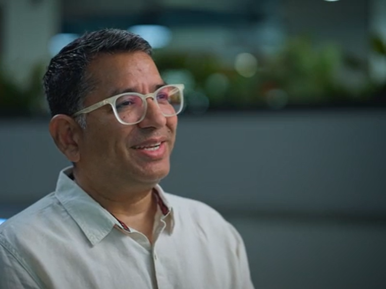 a man wearing glasses and smiling