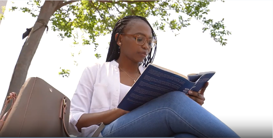a woman sitting on a bench reading a book